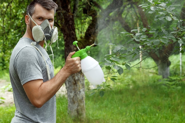 L'homme dans le respirateur arrose les plantes