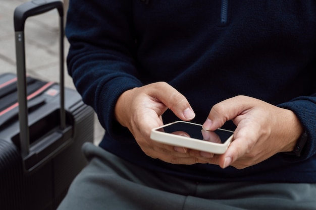 Homme dans la rue du centre-ville commandant un taxi à l'aide d'une application pour téléphone intelligent Réservation d'un taxi à l'aide d'une application en ligne sur un téléphone intelligent