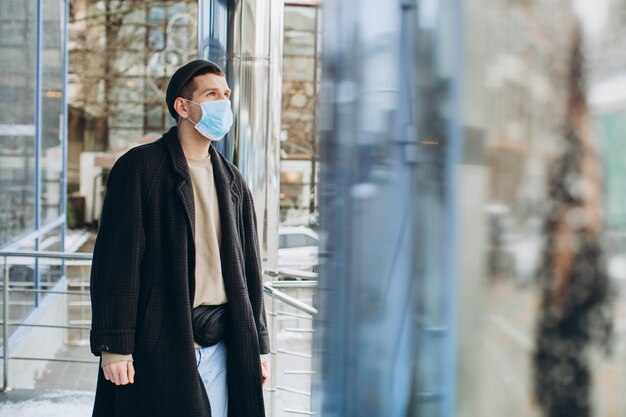 Homme dans la rue portant un masque de protection.