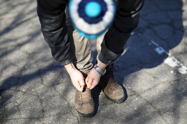 Homme dans la rue se pencha et lacets attachés