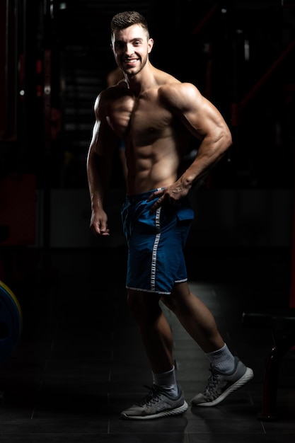 Homme dans la salle de gym montrant son corps bien formé