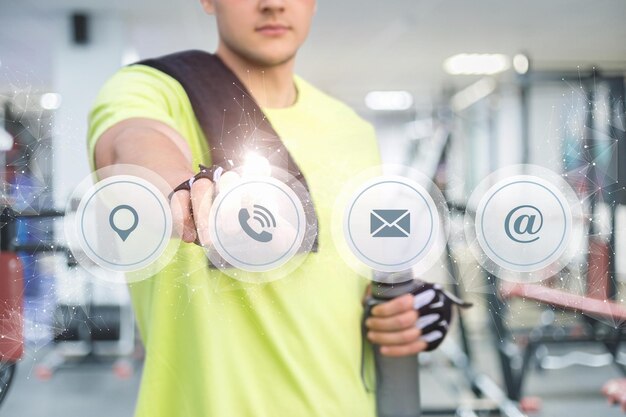 Un homme dans une salle de sport avec un écran sur lequel est écrit "email"