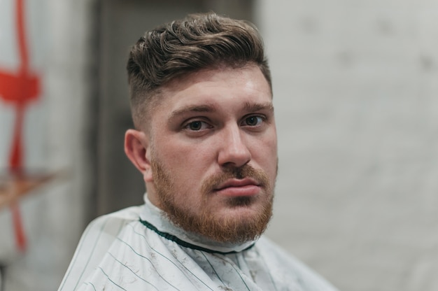 Un homme dans un salon de coiffure pour les coupes de cheveux et le rasage