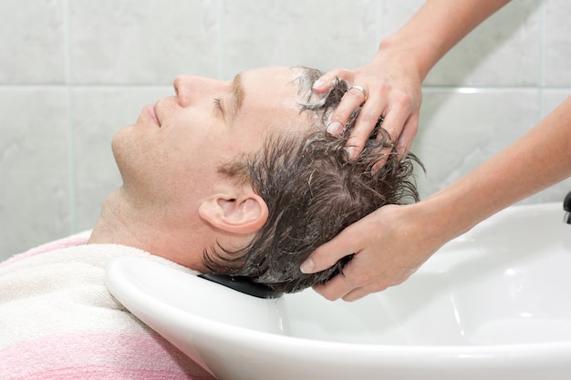 L'homme dans un salon se lave les cheveux