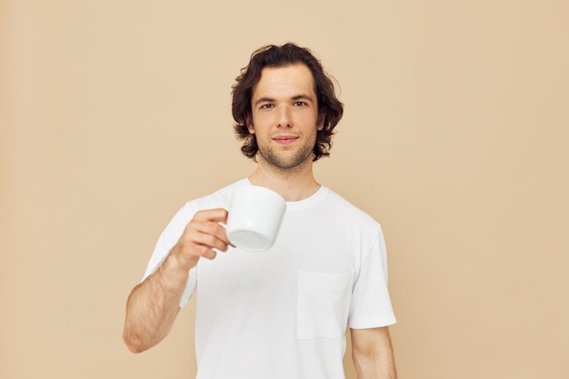 Homme dans un t-shirt blanc avec une tasse à la main fond isolé