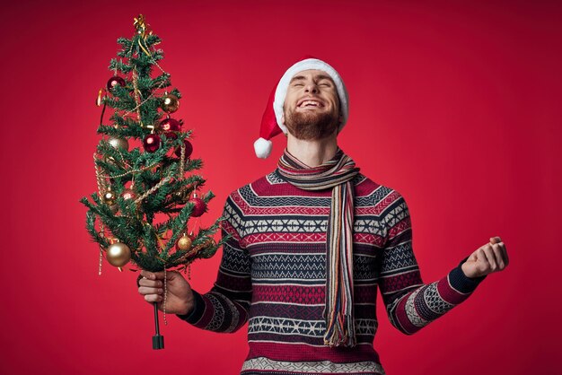 Homme dans les vêtements du Nouvel An Arbre de Noël dans les mains jouets émotions de vacances