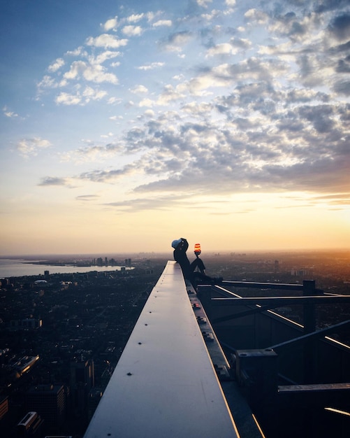 Photo un homme dans la ville contre le ciel au coucher du soleil