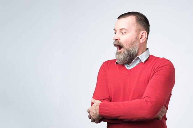 Homme debout avec la bouche ouverte regardant de côté