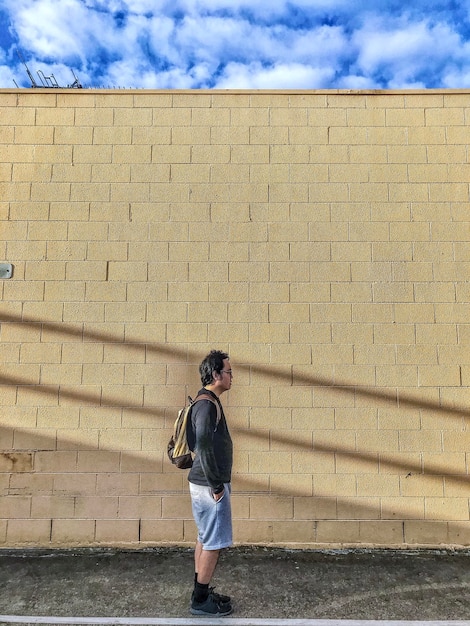 Photo un homme debout contre le mur avec des ombres.