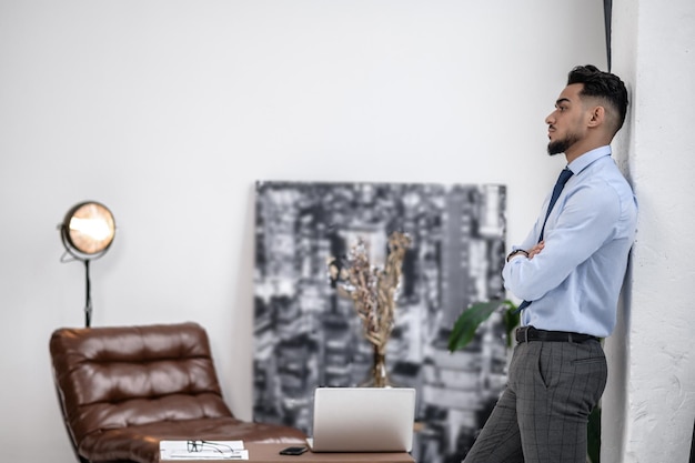 Homme debout sur le côté de l'appareil photo avec les mains jointes