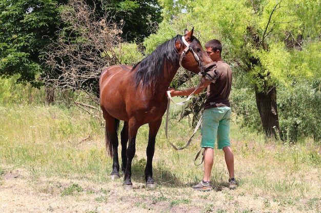 Un homme debout à côté d'un cheval