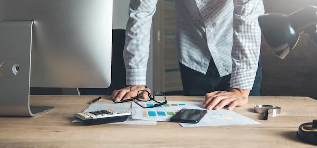 Homme debout à côté de son bureau