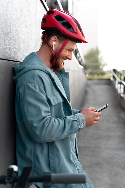 Homme Debout à Côté De Son Scooter Tout En Vérifiant Son Téléphone