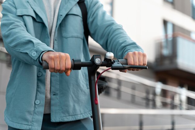 Homme debout à côté de son scooter