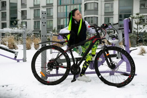 Un homme debout à côté d'un vélo dans la neige