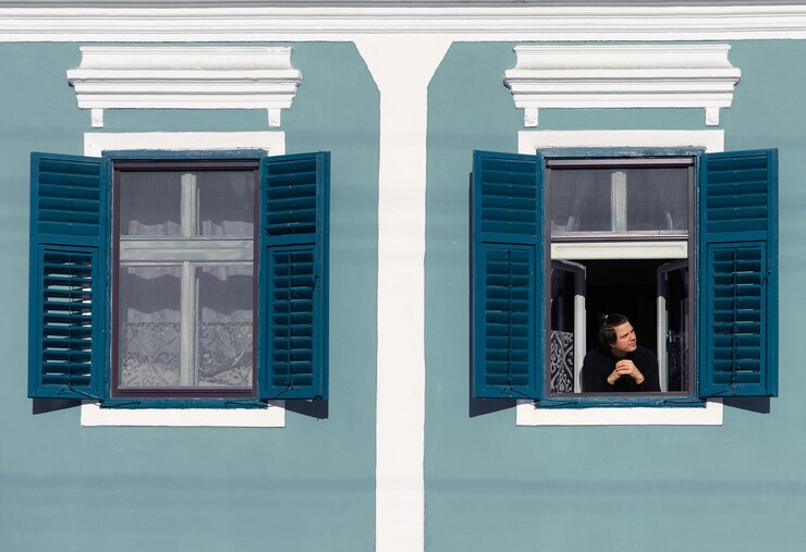 Photo un homme debout sur une fenêtre d'un bâtiment