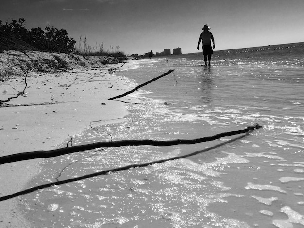 Photo un homme debout sur la plage contre le ciel