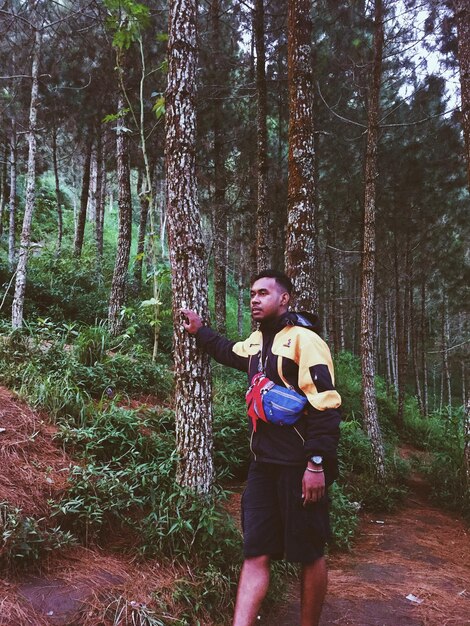 Photo un homme debout près des arbres dans la forêt