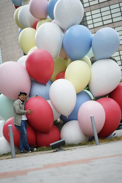 Photo l'homme debout près des ballons