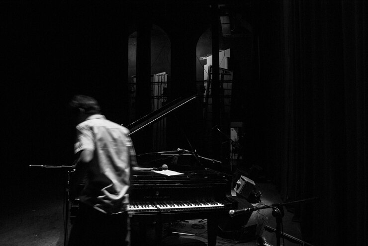 Photo un homme debout près du piano dans la chambre noire