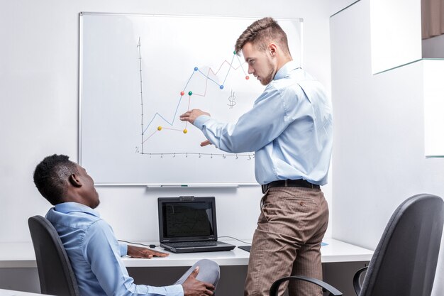 Homme debout près du tableau blanc et pointant sur la carte