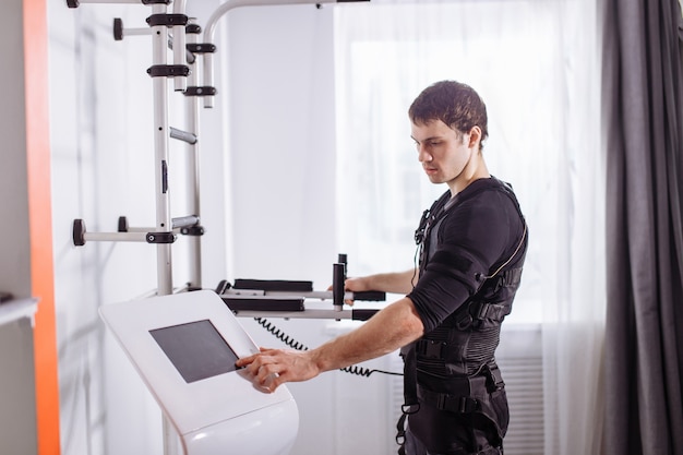 Homme debout près d'une machine EMS