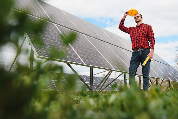 Homme debout près de panneaux solaires Le panneau solaire produit de l'énergie verte et écologique à partir du soleil