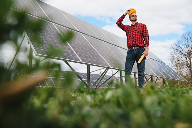 Homme debout près de panneaux solaires Le panneau solaire produit de l'énergie verte et écologique à partir du soleil