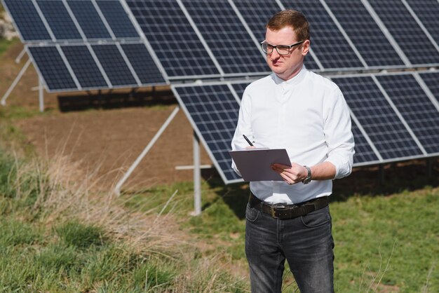 Homme debout près de panneaux solaires