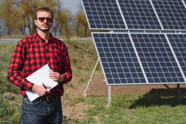 Homme debout près de panneaux solaires