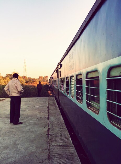 Photo un homme debout sur le quai de la gare.