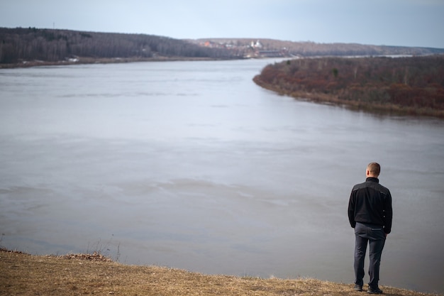 Homme debout sur la rive du fleuve et contemplant