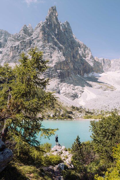 Photo un homme debout sur le rocher surplombant le lac sorapis