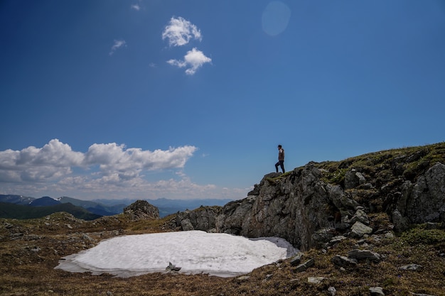 Un homme debout sur des rochers en face de fond de ciel