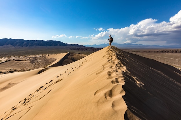 Photo homme, debout, sommet, sable, dune