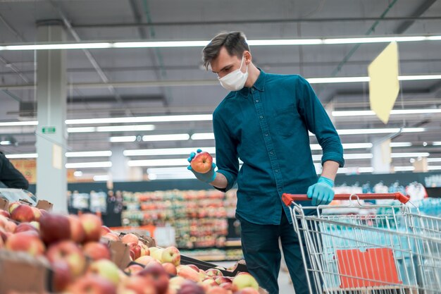 Homme décontracté achetant des fruits pendant la période de quarantaine. notion de sécurité