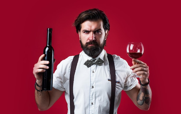 Homme dégustant un verre de vin rouge dans un restaurant barman offre vin sommelier