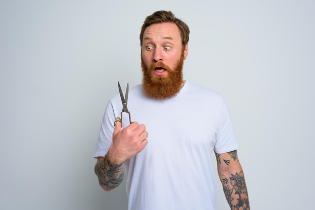 L'homme demandé avec des ciseaux est prêt à couper la barbe