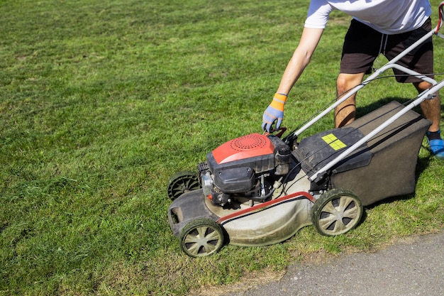 L'homme démarre le moteur de la tondeuse à gazon à essence