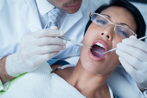 Homme dentiste examinant les dents d&#39;une femme