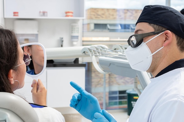 Homme dentiste avec un patient dans une clinique dentaire