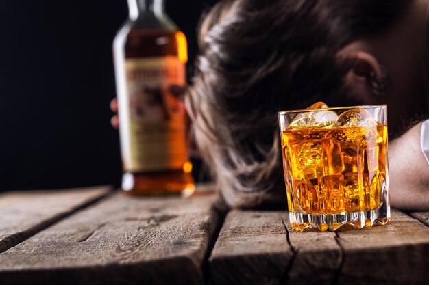 Photo homme dépendant de l'alcool avec un verre homme adulte déprimé triste ayant des problèmes avec l'alkohol