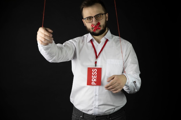 Homme déprimé tient les mains attachées avec des cordes avec la bouche d'emballage par du ruban adhésif