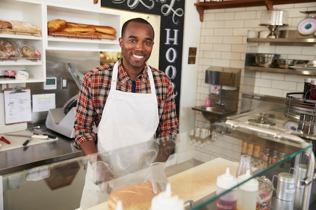 Homme derrière le comptoir d'une sandwicherie à la recherche d'appareil photo