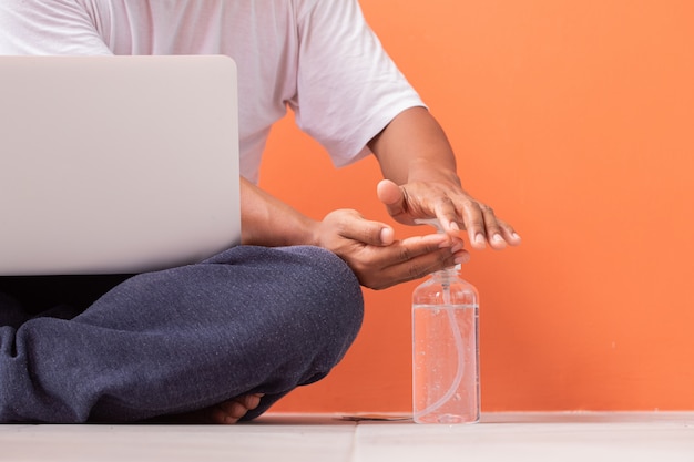 Photo homme désinfectant les mains avec du gel, restez à la maison.