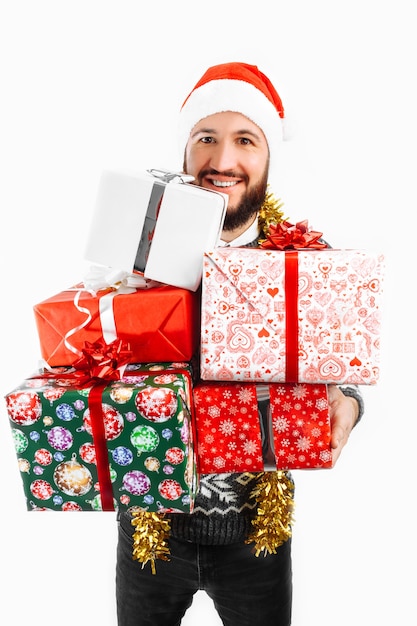 L'homme détient beaucoup de cadeaux de Noël dans le Studio sur un fond blanc choisir un cadeau