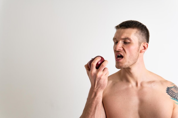 Homme détient des pommes en fitness fond blanc isolé fit fitness adulte sexy mâle muscle portrait formation personne main tenir nutrition bodybuilder poitrine