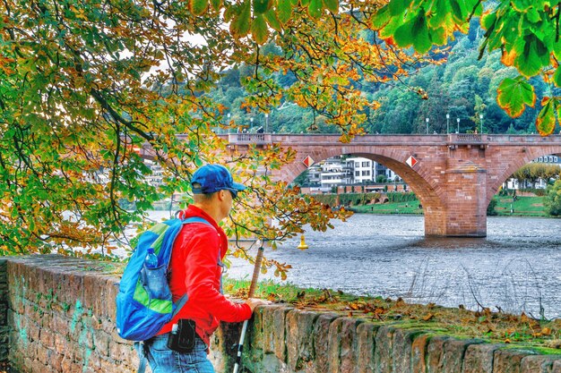 Photo un homme détournant le regard alors qu'il se tient près du mur de pierre