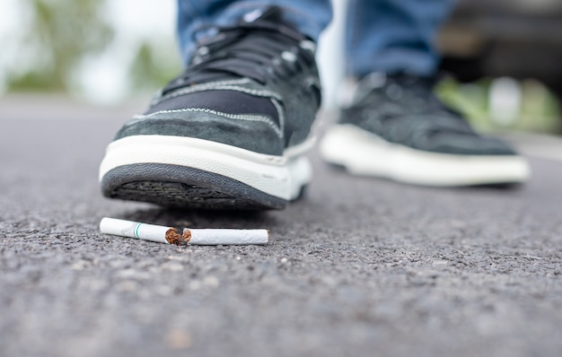 L'homme détruit la cigarette à pied