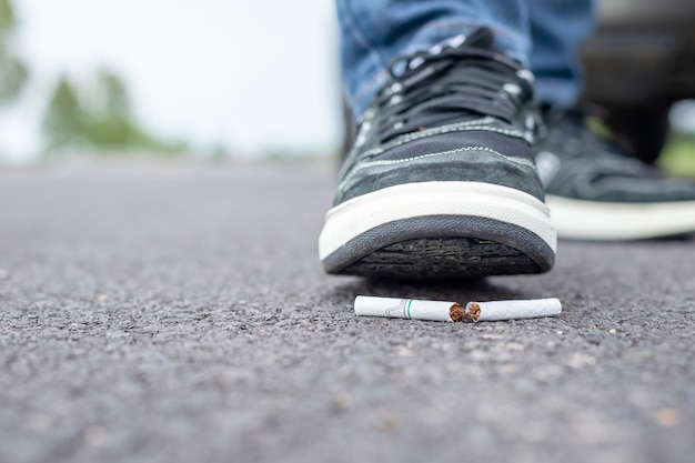 L'homme détruit la cigarette à pied